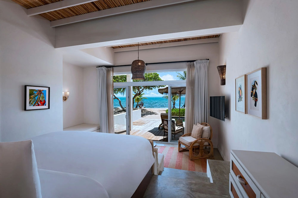 Primary guest room at Itz'ana Belize Resort & Residences — full-room view, natural lighting, clear sightlines, PressBeyond standard