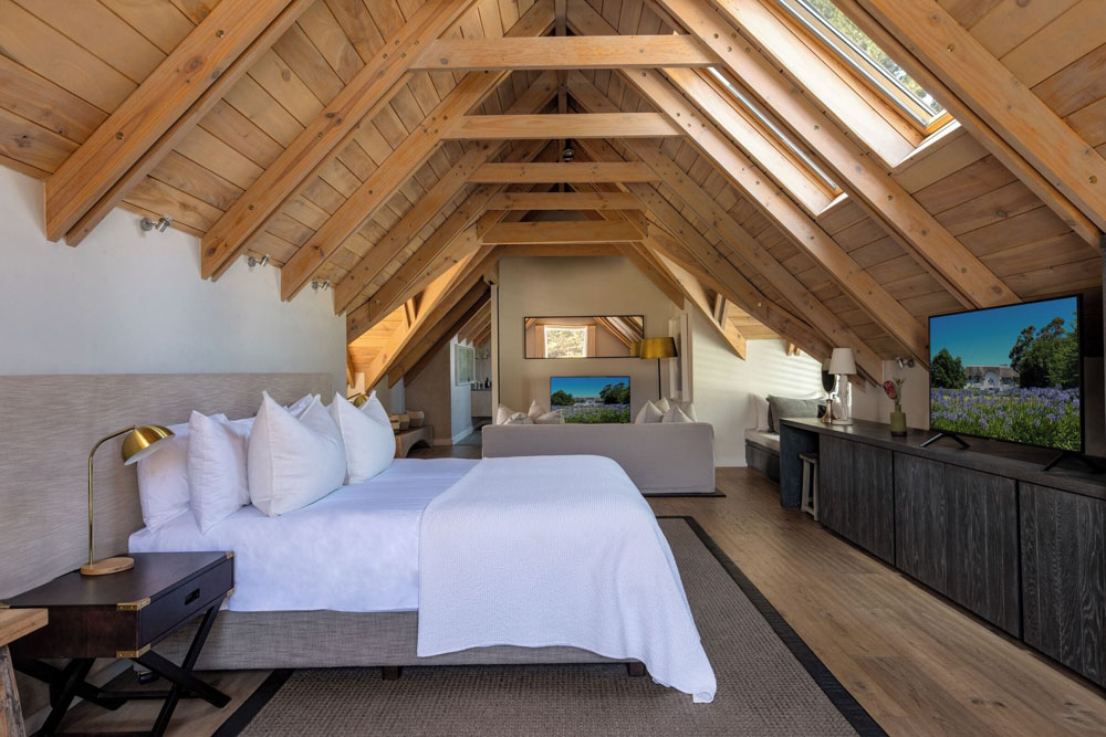 Primary guest room at Mont Rochelle — full-room view, natural lighting, clear sightlines, PressBeyond standard