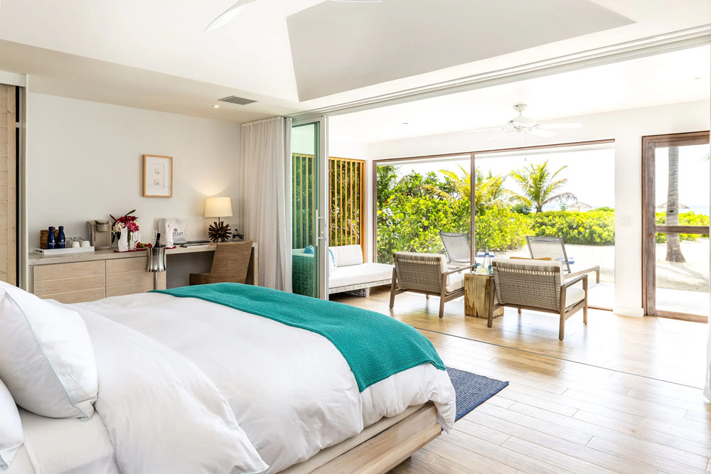 Primary guest room at Pine Cay — full-room view, natural lighting, clear sightlines, PressBeyond standard
