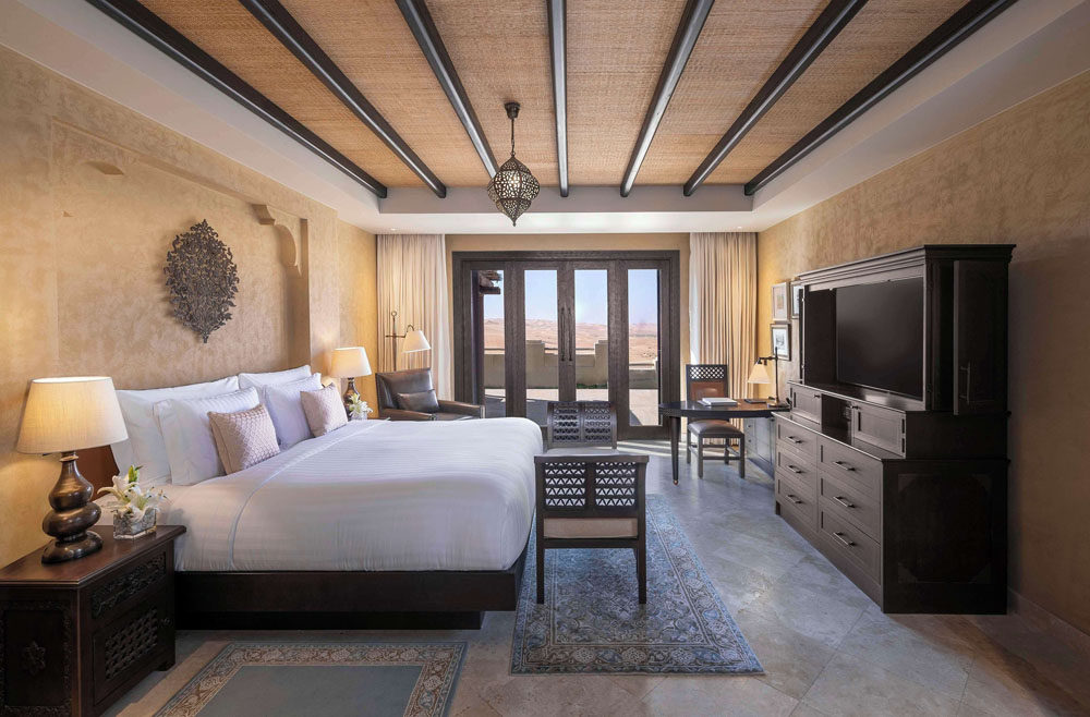 Primary guest room at Qasr Al Sarab Desert Resort By Anantara — full-room view, natural lighting, clear sightlines, PressBeyond standard