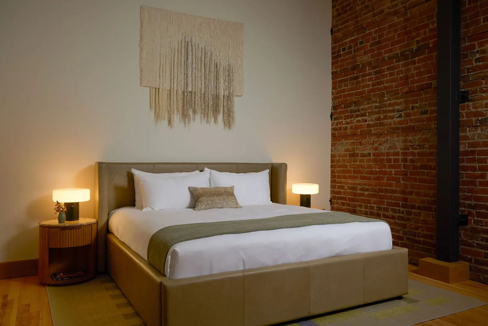 Primary guest room at Tributary Hotel — full-room view, natural lighting, clear sightlines, PressBeyond standard