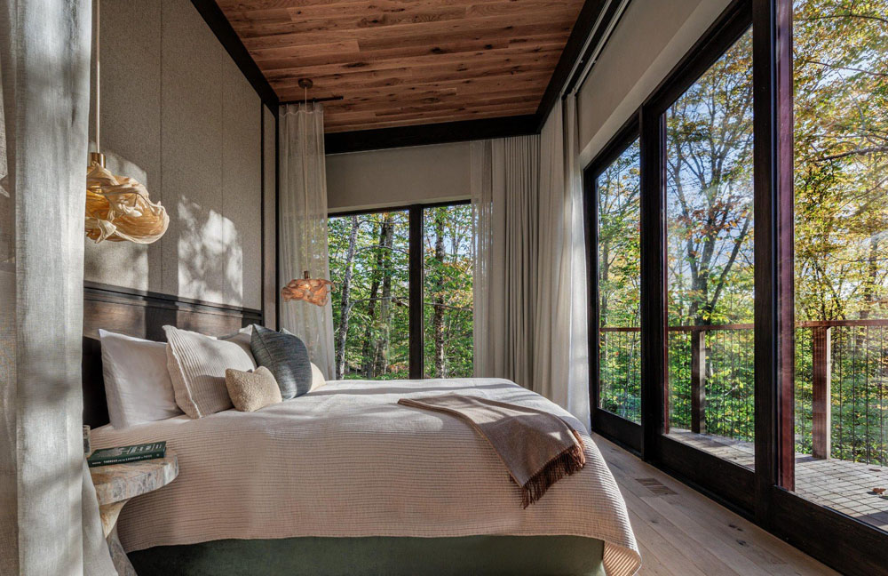 Primary guest room at Twin Farms — full-room view, natural lighting, clear sightlines, PressBeyond standard